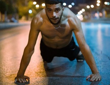 topless man in black shorts kneeling on floor